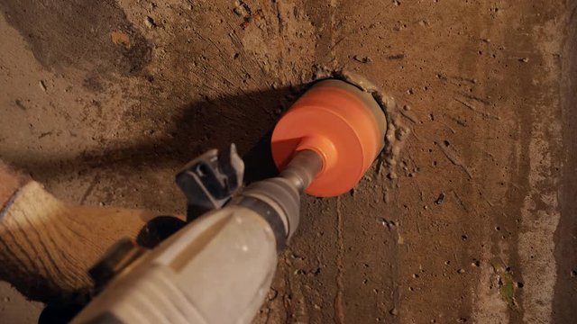 Worker using hammer drill on site