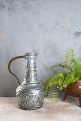 Vintage metal vase and green plant