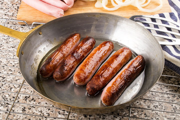 home made british sausages in a brass pan