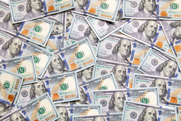 One hundred dollar bills on the table as background