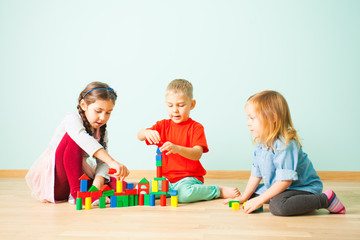 Young kids constructing towers from wooden blocks