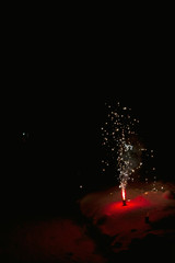 Bright colorful multicolored fireworks fountain in the snow at night