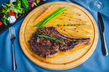 beef steak with salad, bread and wine on the table