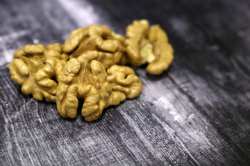 Walnuts kernels on vintage dark wooden table. Peeled nuts close-up, healthy eating concept