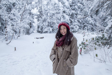 Fototapeta na wymiar Portrait of woman with red wool hat feeling very happy and cold under snowy weather at Shin-hotaka, Japan Alps.