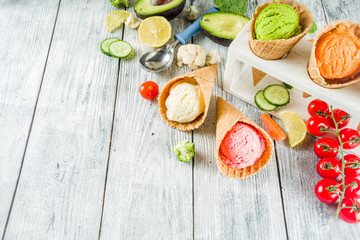 Trendy vegan food, summer healthy dessert concept, colorful diet vegetable ice cream with avocado, cucumber, tomato, beet, carrot, broccoli, cauliflower. Frozen veggie smoothie, wooden background