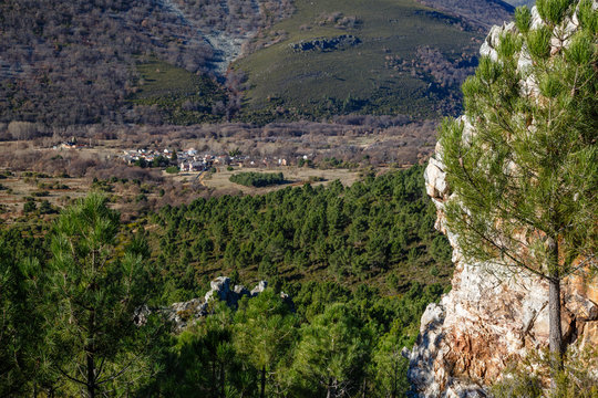 Pared de roca, pinar y pueblo de Morla de la Valdería. La Cabrera, León, España.