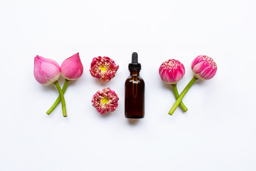 Lotus essential oil with lotus flowers on white.