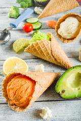 Trendy vegan food, summer healthy dessert concept, colorful diet vegetable ice cream with avocado, cucumber, tomato, beet, carrot, broccoli, cauliflower. Frozen veggie smoothie, wooden background