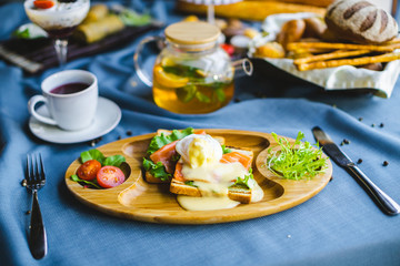 sandwich with salmon and egg on a wooden plate. breakfast