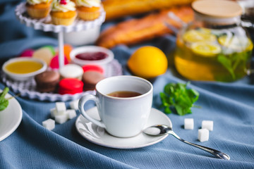 picnic. green tea in a teapot. tea in a cup. cupcakes on a plate