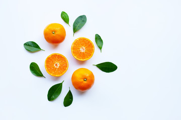 Fresh orange citrus fruit with green leaves on white.