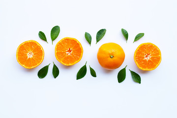 Fresh orange citrus fruit with green leaves on white.