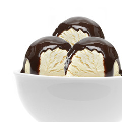 Vanilla ice cream scoops with chocolate syrup, sauce or sherbet in bowl isolated on white background