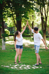 A young couple celebrate victory playing tic-tac-toe in the park