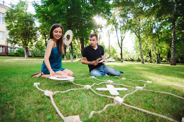 Friends playing tic-tac-toe on green grass