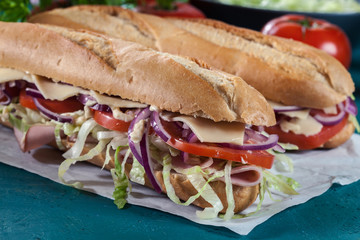 Submarine sandwiches with ham, cheese and vegetables