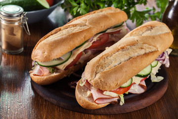 Submarine sandwiches with ham, cheese and vegetables