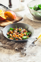 Roasted pumpkin salad with spinach and nuts