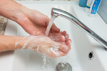 A man washes his hands from the thick suds