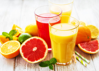 Glasses of juice and citrus fruits