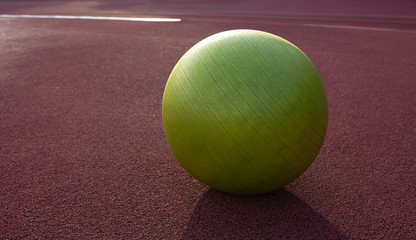 Closeup shot of a fitness ball at the stadium in sunny evening. Empty space