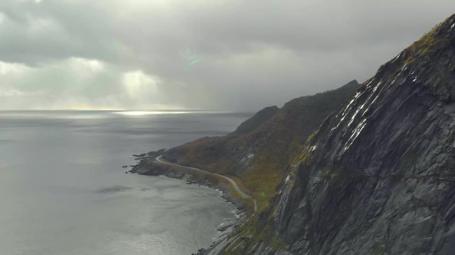 Sea cliff aerial shot, Norway. Sun and clouds in the sea.