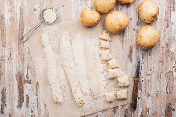Homemade uncooked potato gnocchi. Raw Italian dumplings on a floured wooden board in a kitchen