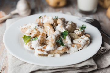 Homemade potato gnocchi in a plate. Raw Italian dumplings on a floured wooden board in a kitchen