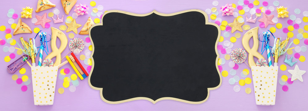 Purim celebration concept (jewish carnival holiday) over wooden pink background. Banner.
