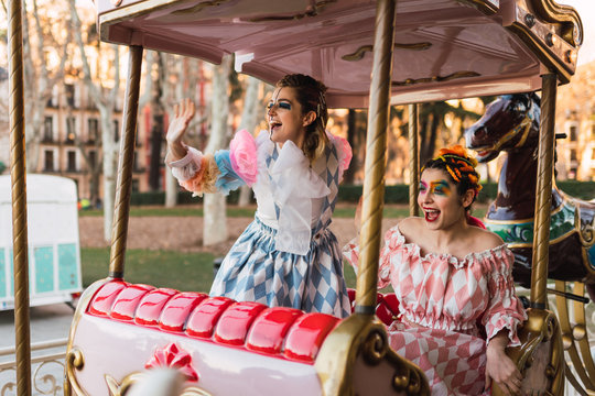 Street artists sitting on merry-go round on fairground