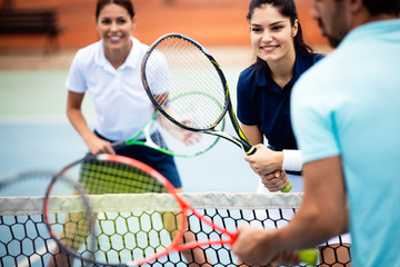 Fit happy poeple playing tennis together. Sport concept