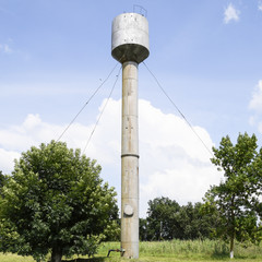 Silver Water Tower among green grass and trees