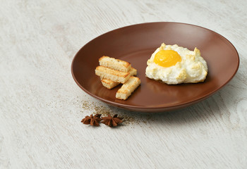 Orsini egg and croutons on a brown plate.