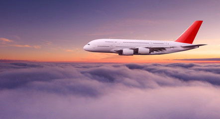 Fototapeta na wymiar Huge two-storey passengers commercial airplane flying above dramatic clouds, sunset.