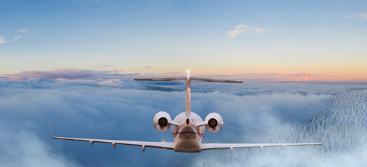 Small private jetplane flying above beautiful clouds.