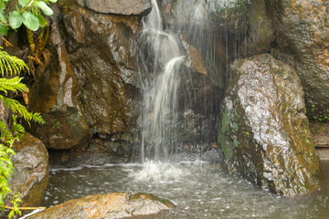 Waterfall over rocks in garden 