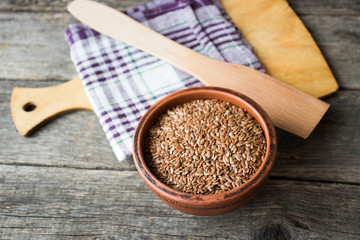flax seeds in a clay pot on a wooden table