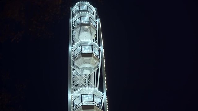 Part of beautifully lighted ferris wheel against a night sky background.