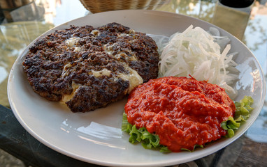 Traditional serbian and balkan dish Pljeskavica with sauce, Maribor,Slovenia
