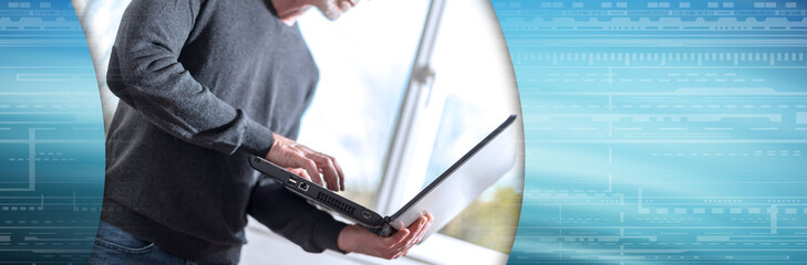 Businessman standing and working on his laptop. panoramic banner