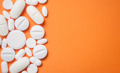 closeup of white pils on orange background