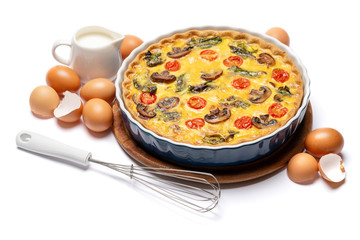 Baked homemade quiche pie in ceramic baking form, eggs and cream