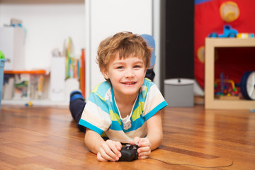 a boy playing with radio-controlled car at home.