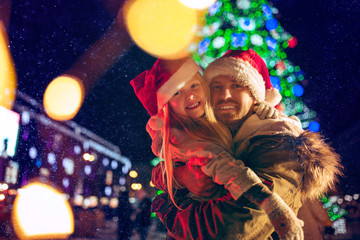 family, christmas, holidays, season and people concept - happy family over lights city background...