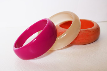 Brightly colored stack of bangle bracelets against white background