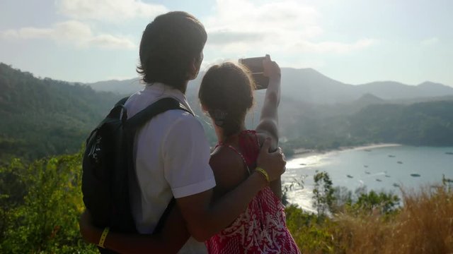 Traveler couple posing taking selfie using smartphone standing on top of mountain. 3840x2160