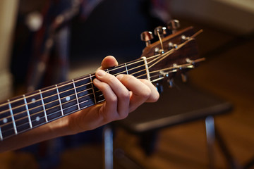 man playing guitar and holding a chord
