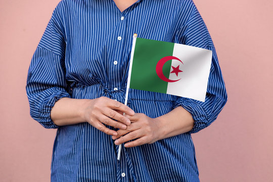 Algeria flag. Close up of a woman's hands holding Algerian flag.