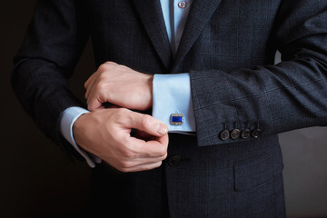 Close-up of a man in a tux fixing his cufflink. groom bow tie cufflinks